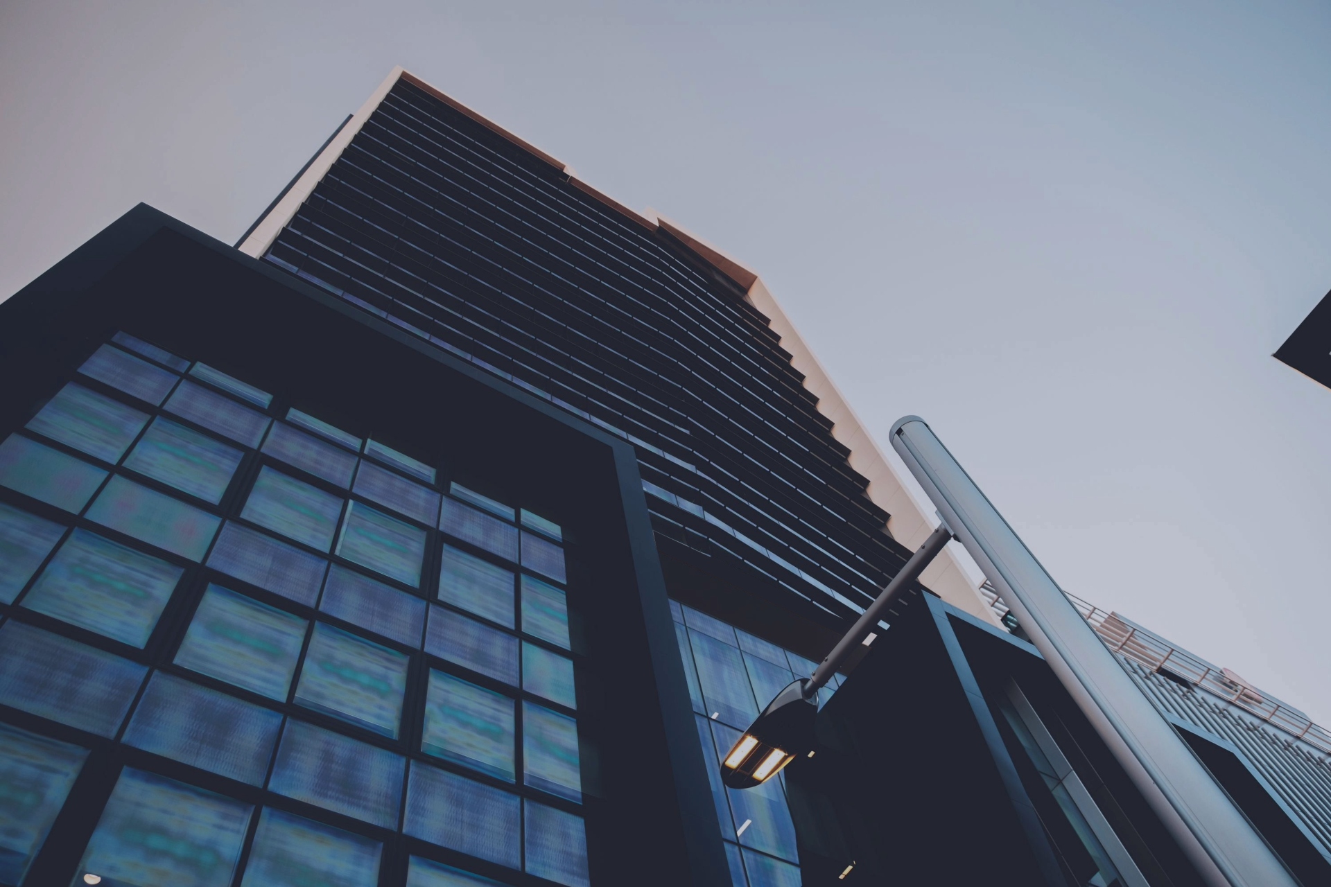 Modern commercial office building with reflective glass windows viewed from below